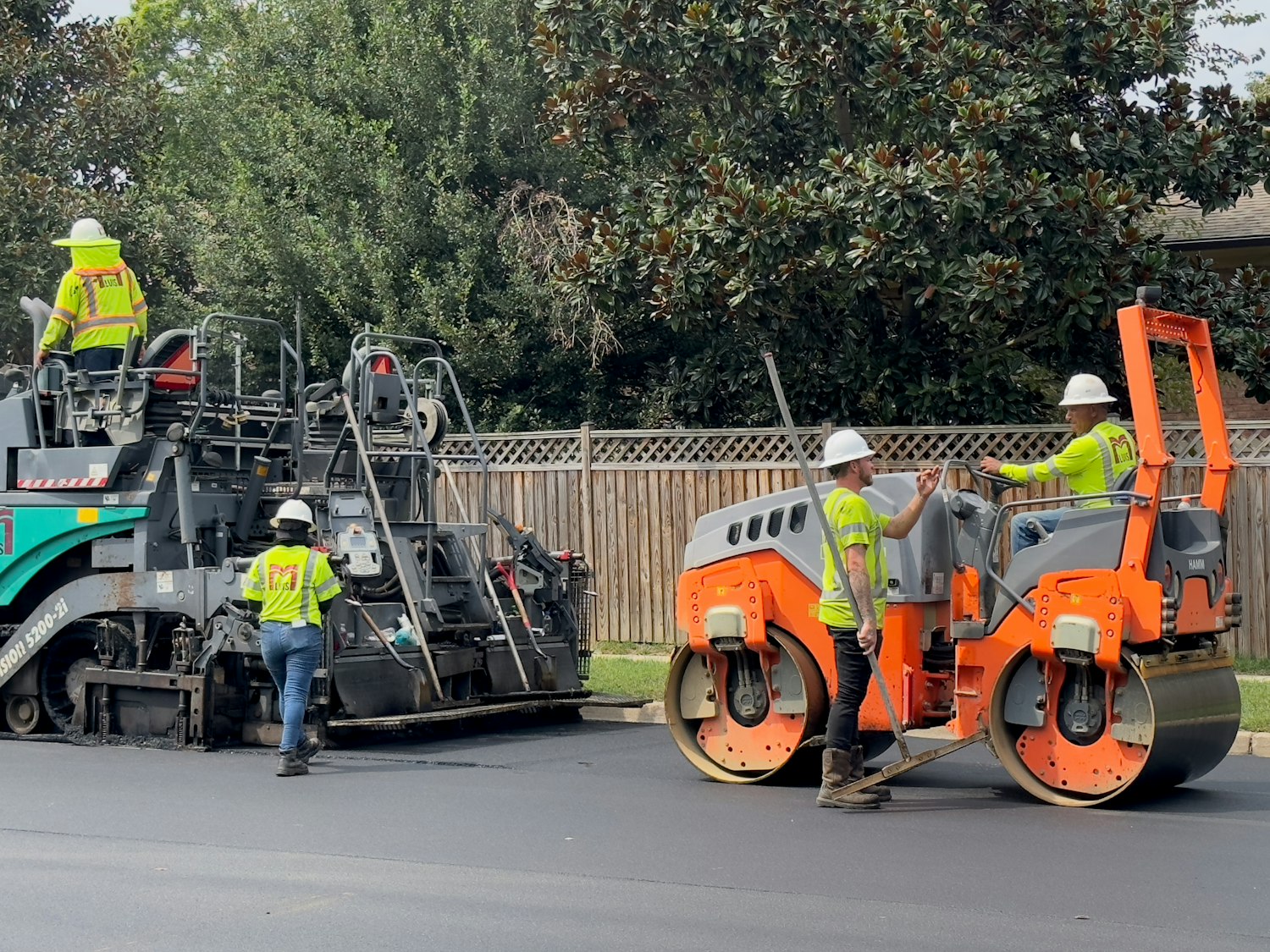 Road paving with a roller